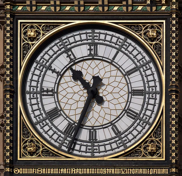 Close-up of a Great Clock of Westminster dial, photographed in 2009, with Gothic Roman numerals; four o'clock is written IV.